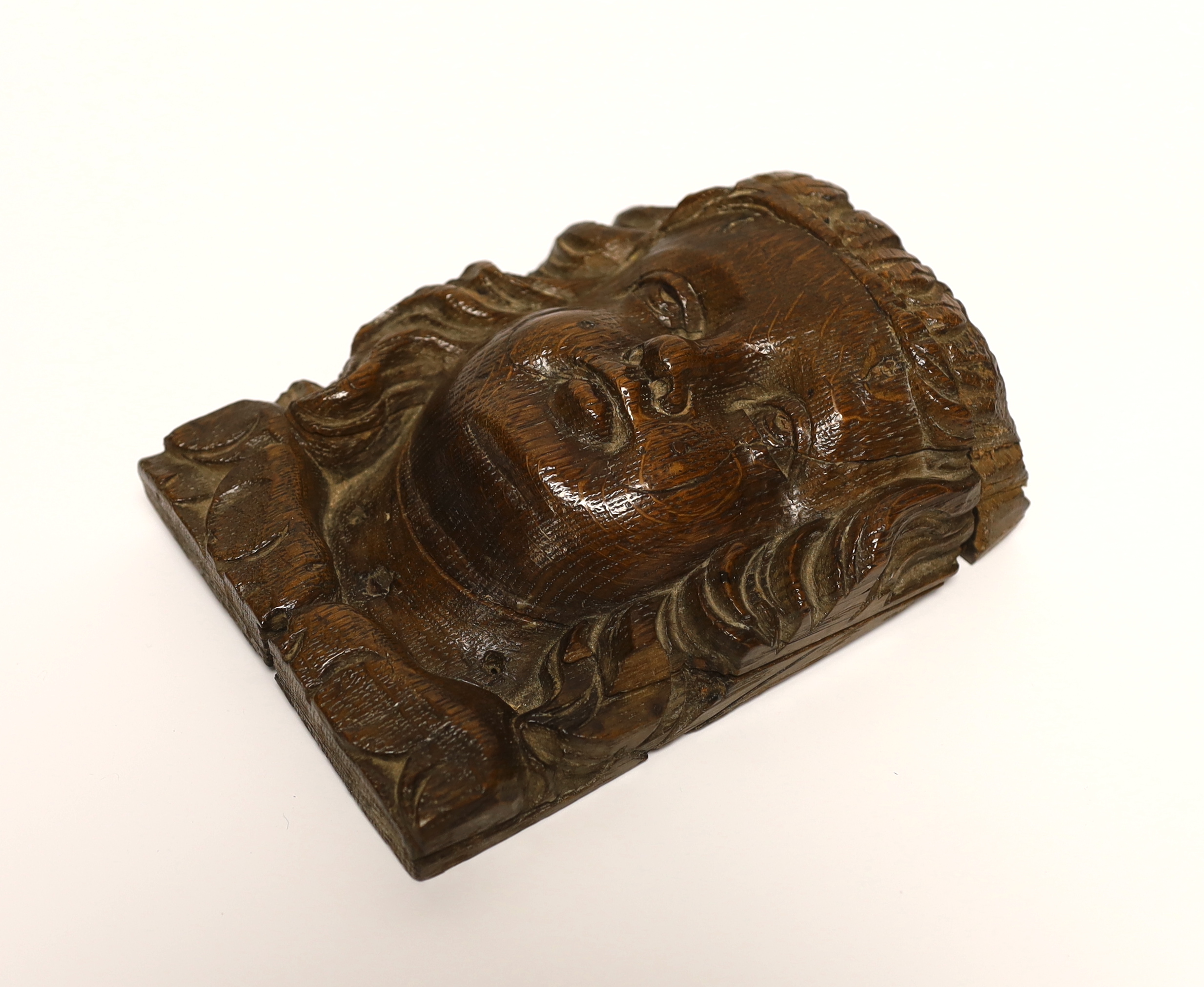 A 17th century carved oak figural terminal, 16cm high